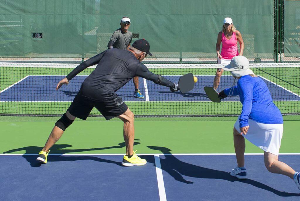 Group of older people playing pickleball