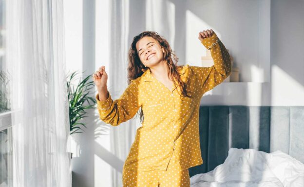 Woman waking up refreshed and stretching