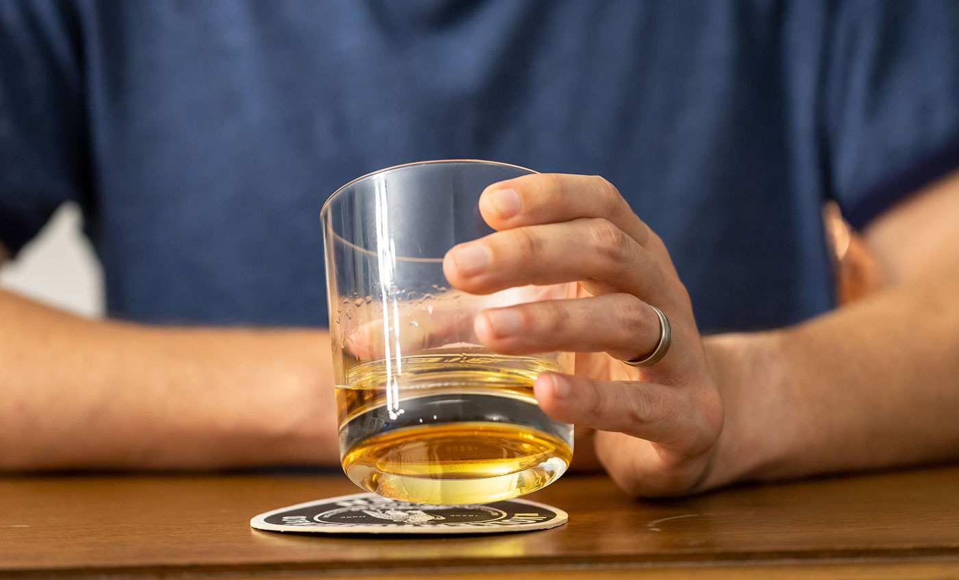 man holding glass of alcoholic beverage